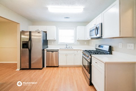 a renovated kitchen with stainless steel appliances and white cabinets