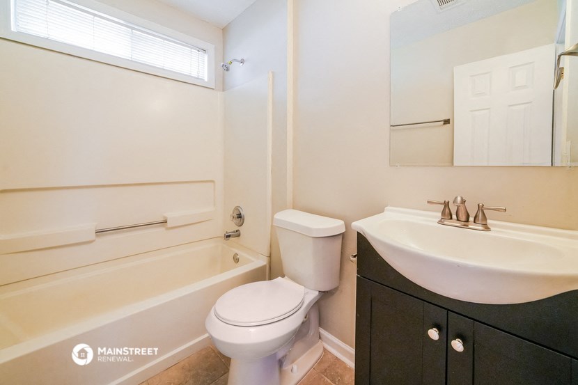 a bathroom with a toilet and a sink and a bath tub