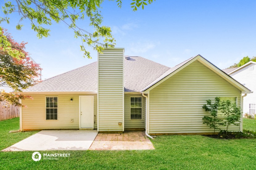 a small yellow house with a yard and a sidewalk