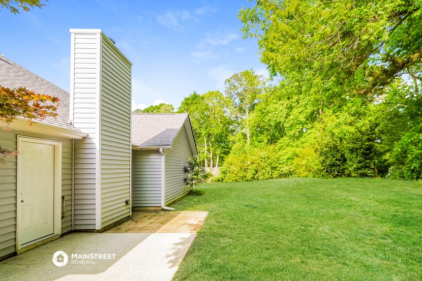 a backyard with a shed and a garage next to a lawn and trees