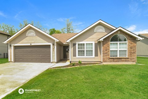 a house with a driveway and a lawn