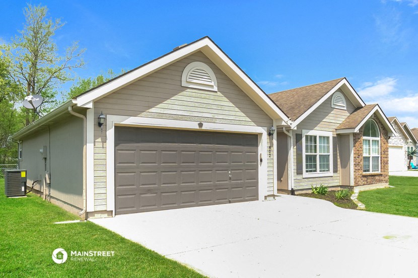 a gray garage door in front of a house