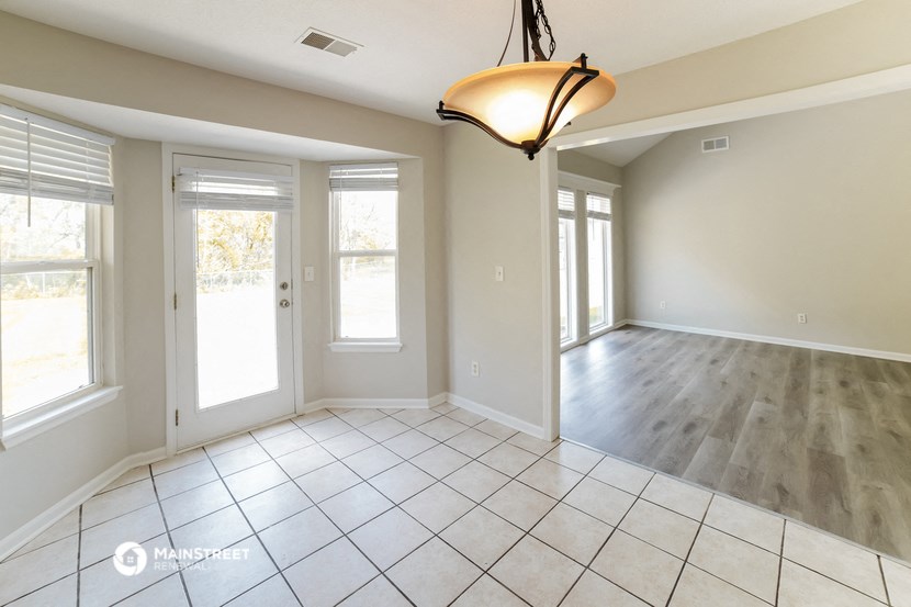 an empty living room with windows and a light fixture