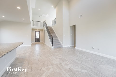 the spacious living room with the staircase leading to the second floor