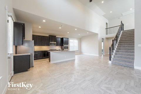 an open kitchen and living room with stairs to the second floor