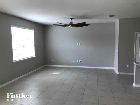 an empty living room with a ceiling fan