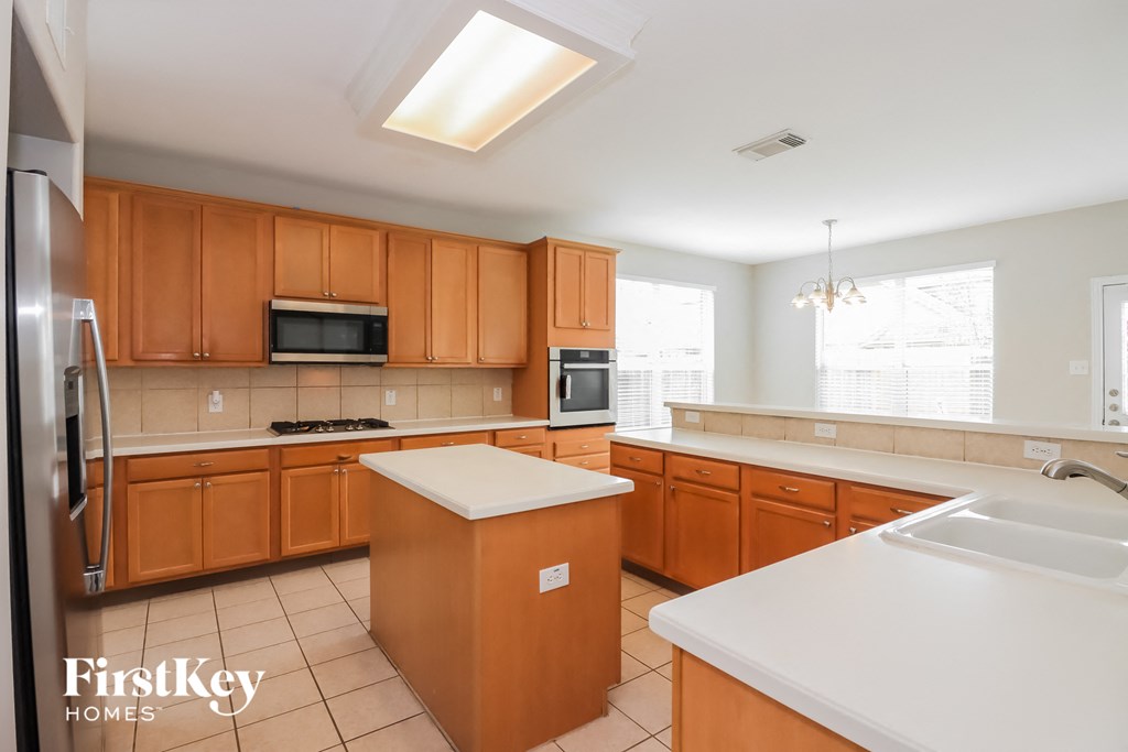 a large kitchen with wooden cabinets and white counter tops