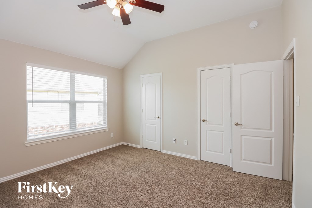 a bedroom with two closets and a ceiling fan