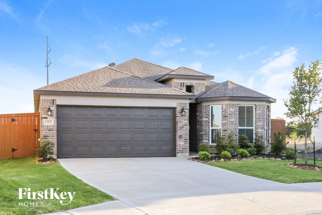 A house with a garage door and a driveway in front of it.