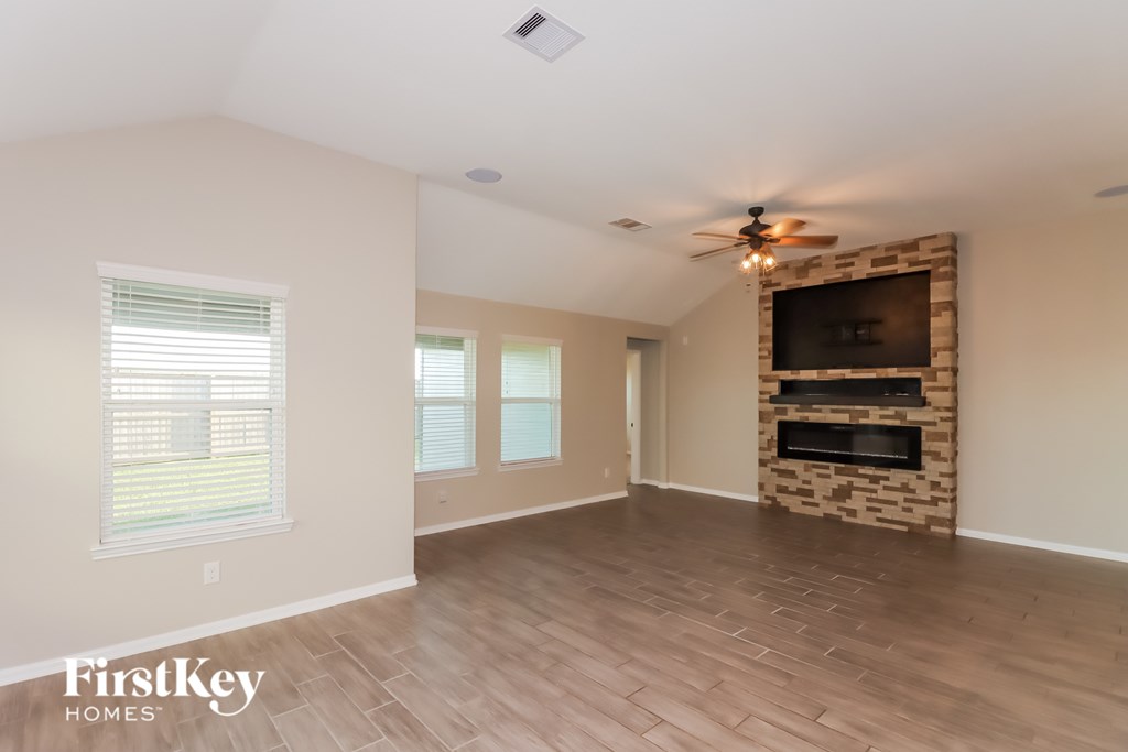 A spacious living room with a fireplace and a flat screen TV.