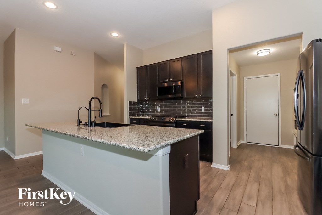 A kitchen with a granite countertop and a refrigerator.