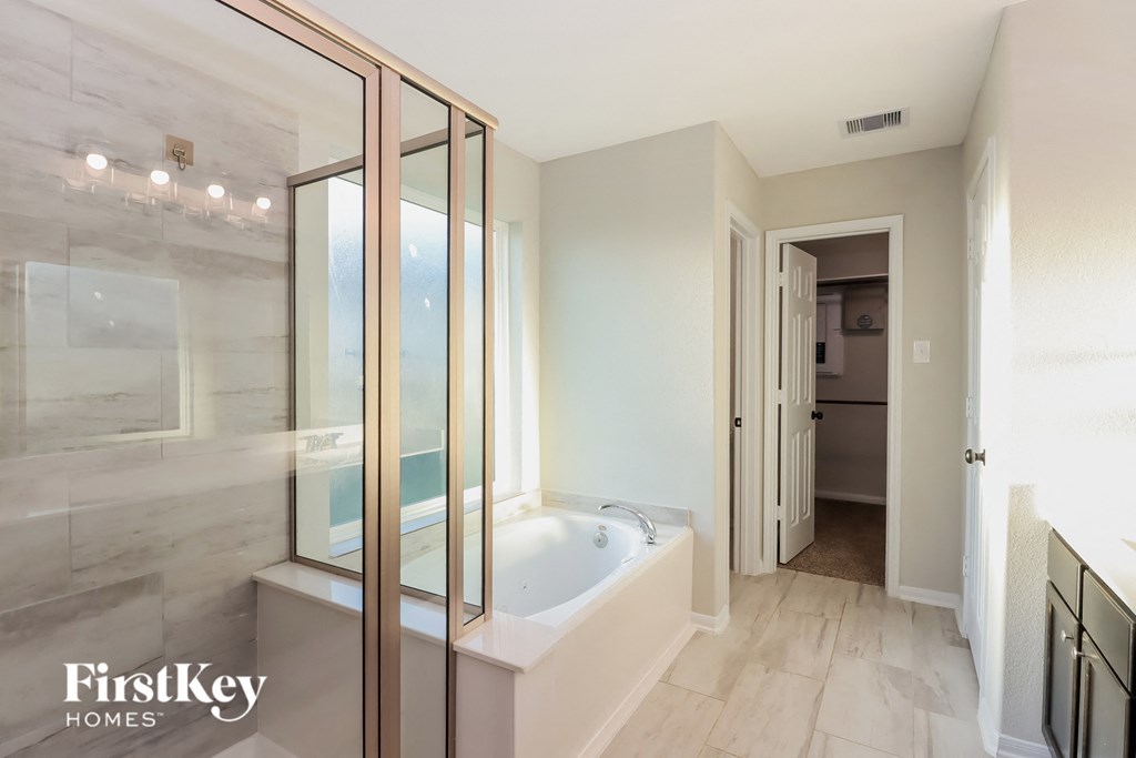 A bathroom with a tub and a walk-in shower.