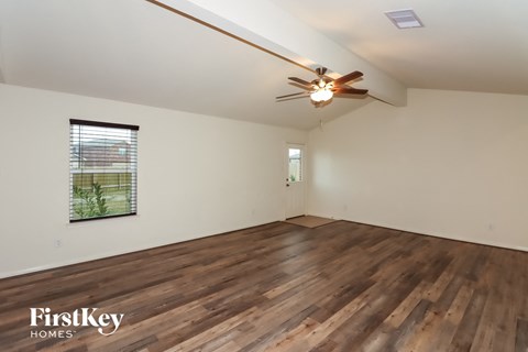 the living room with hardwood flooring and a ceiling fan