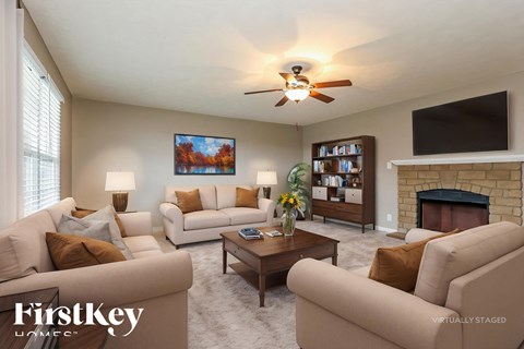 A living room with a fireplace and a painting on the wall.