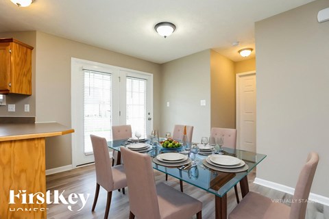 A dining room with a glass table and chairs.