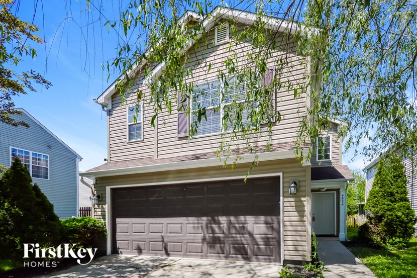 a tan and brown house with a garage door