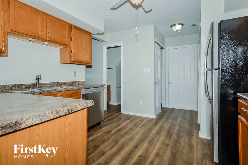 a kitchen with wooden cabinets and a stainless steel refrigerator