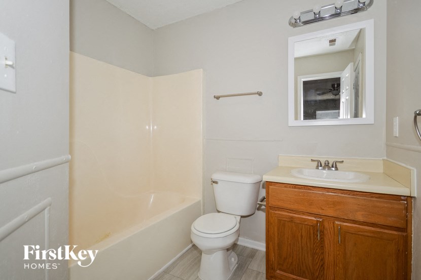 a bathroom with a toilet and a sink and a bath tub