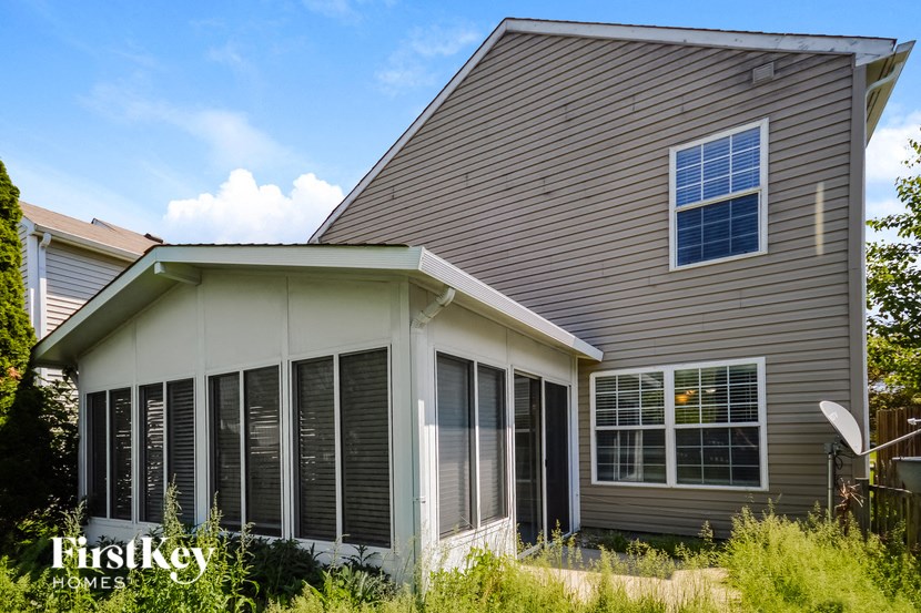 the front exterior of a house with large windows and a porch