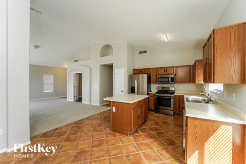 a large kitchen with wooden cabinets and a sink