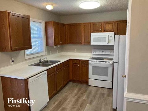 A kitchen with wooden cabinets and white appliances.