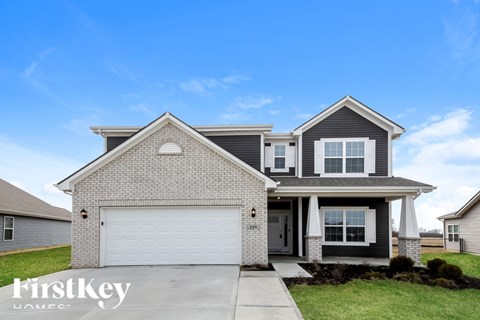 A two-story house with a garage is for sale.