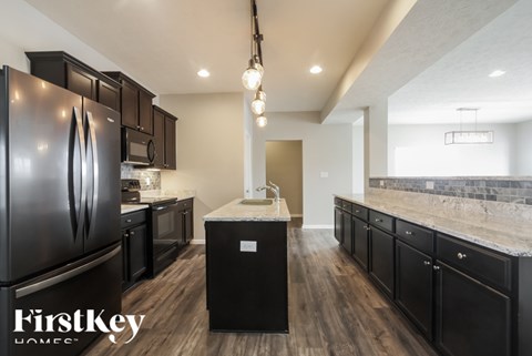A kitchen with black cabinets and a FirstKey logo.