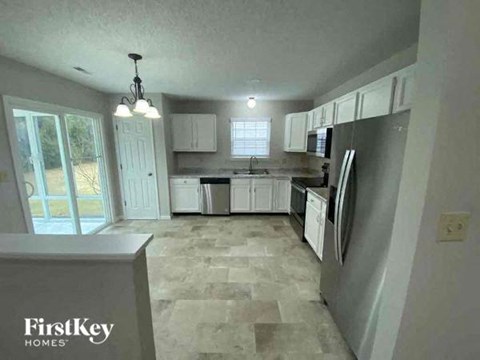 a kitchen with white cabinets and a stainless steel refrigerator