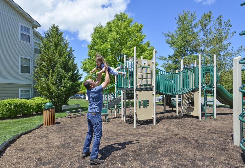 a man is playing with a child on a playground