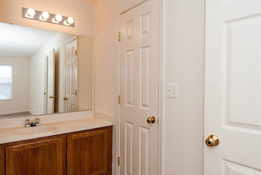 a bathroom with a sink and a mirror and a door