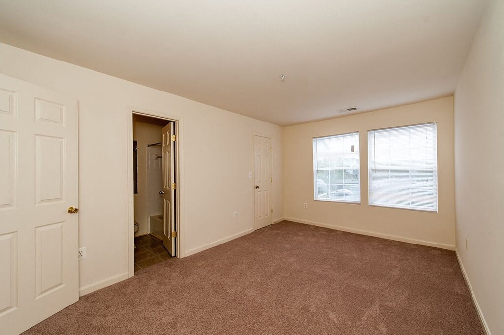 an empty living room with a door and a window