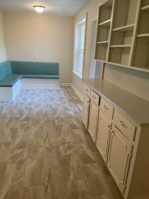 A kitchen with white cabinets and a tile floor.