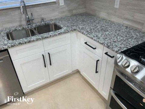 a kitchen with white cabinets and granite counter tops