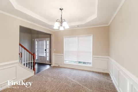 a dining room with a large window and a carpeted floor