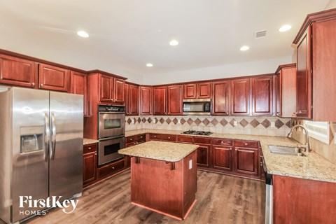 a kitchen with cherry wood cabinets and stainless steel appliances