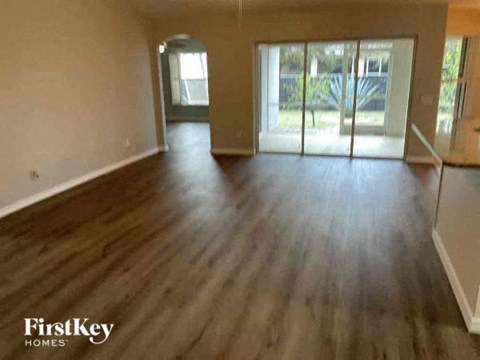 an empty living room with a wooden floor