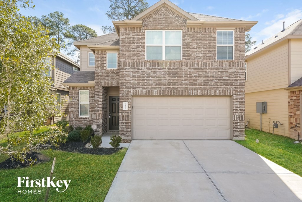 a house with a garage door and a sidewalk in front of it
