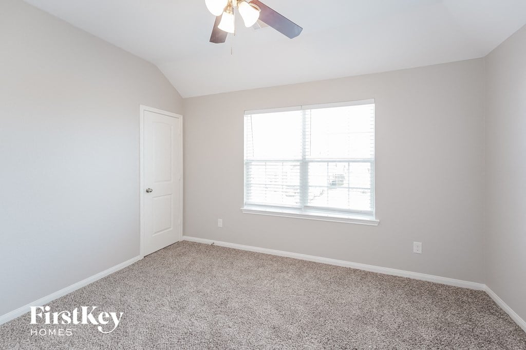 a bedroom with a ceiling fan and a window