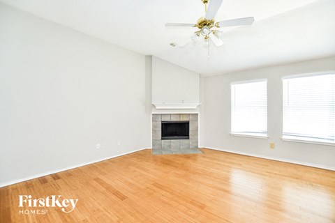 a living room with a fireplace and a wooden floor
