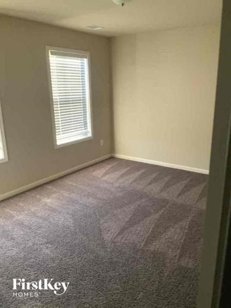 an empty room with a carpeted floor and a window