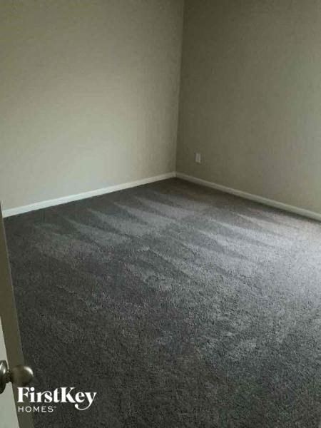 a room with a carpeted floor and a white wall