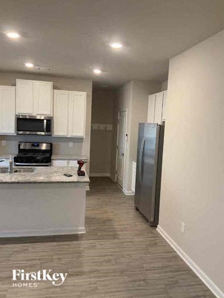 a kitchen with white cabinets and a stainless steel refrigerator