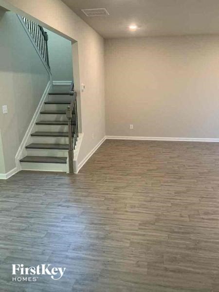 a empty living room with a staircase and wood floors