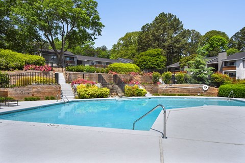 A swimming pool surrounded by a fence and trees.