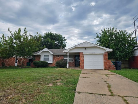 A house with a white garage door and a brick chimney.
