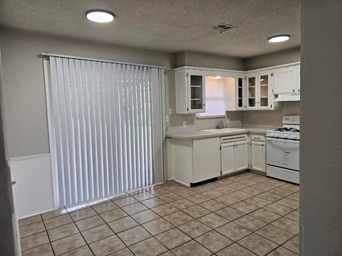 A kitchen with white cabinets and appliances.