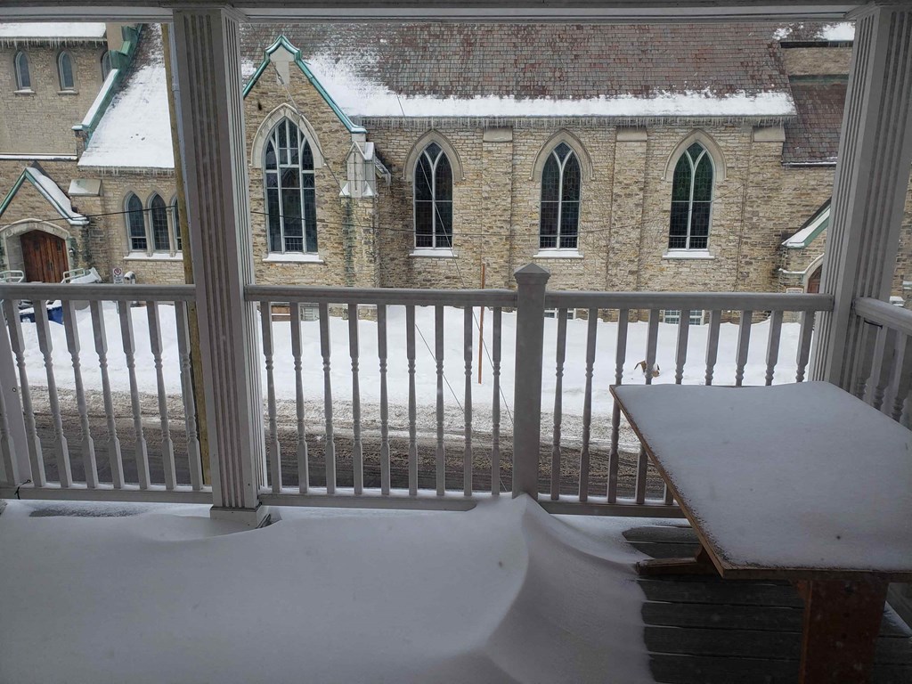 a balcony with a view of a church in the snow