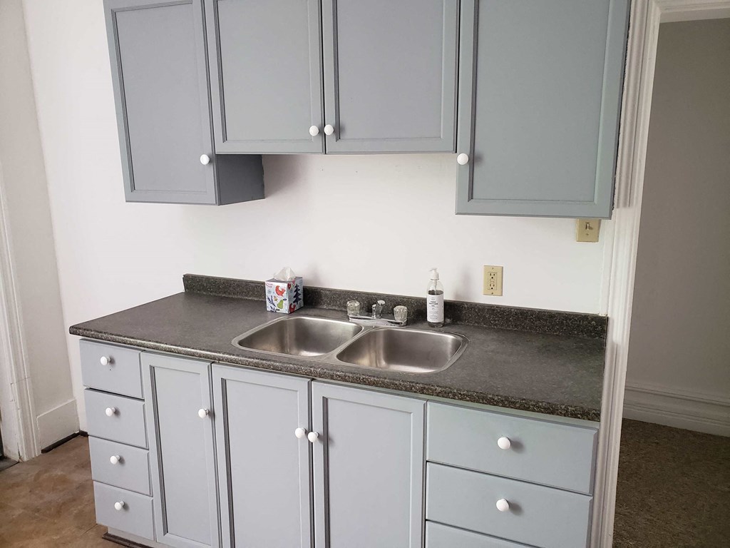 a kitchen with blue cabinets and a sink