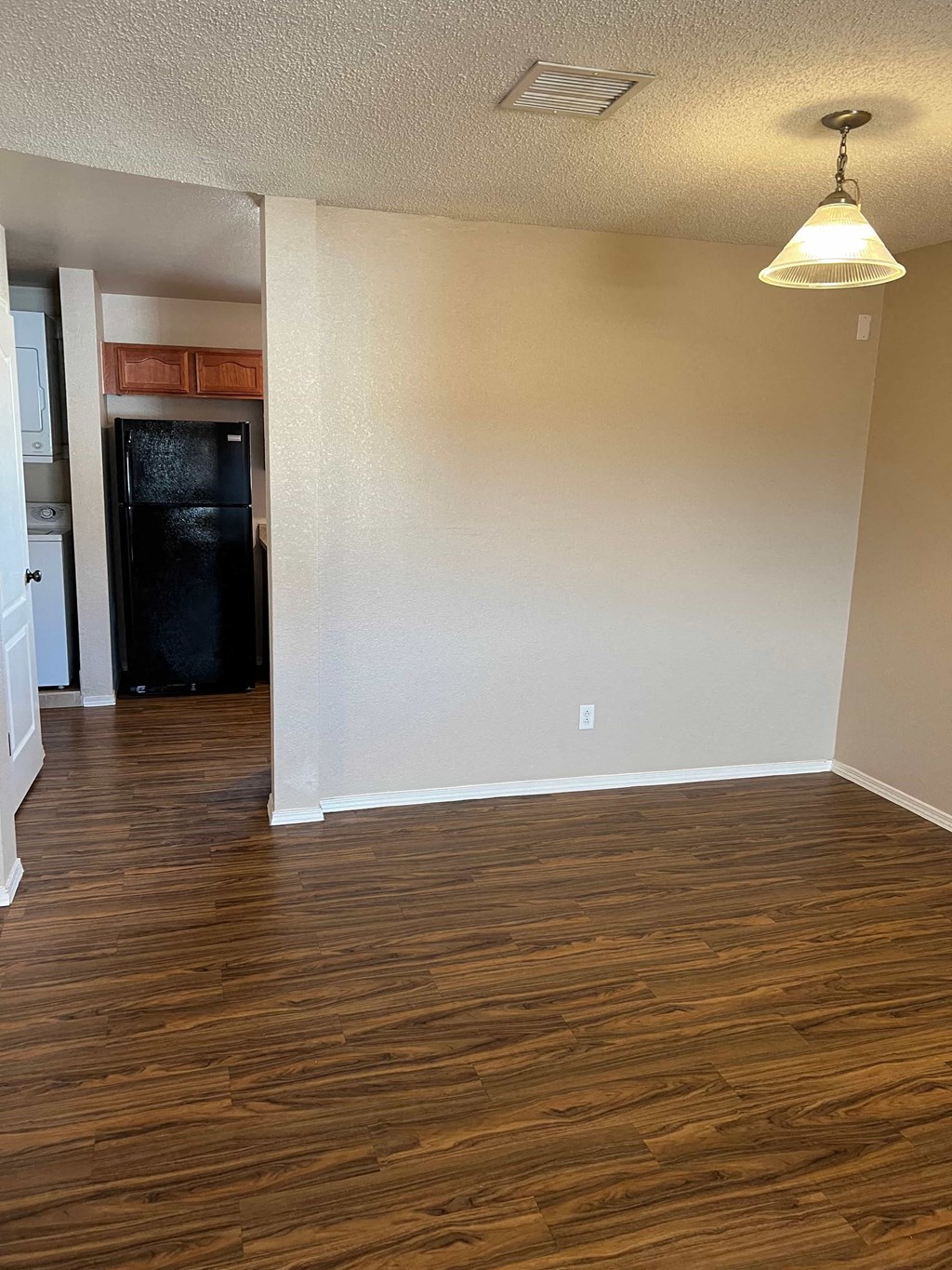 an empty living room with wood flooring and white walls