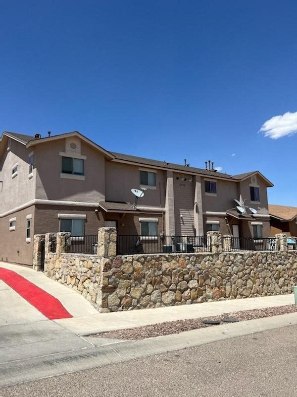 a large building with a stone wall in front of it